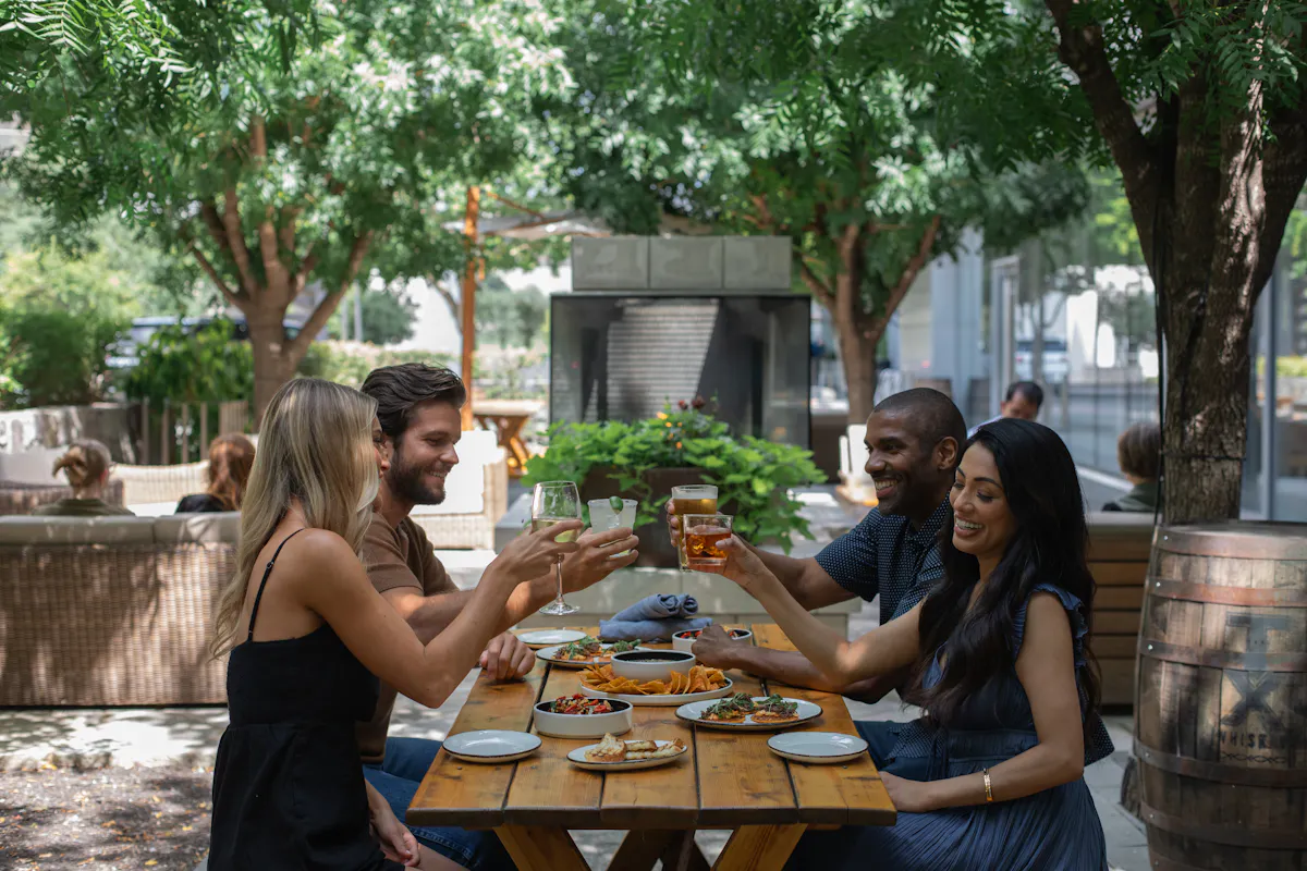 a group of people sitting at a table with food and drinks